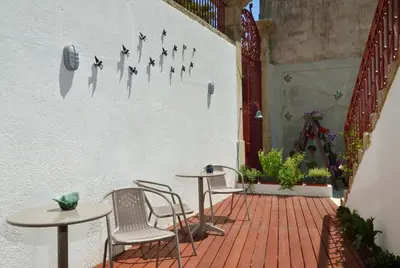 a patio with tables and chairs and a wall with butterflies at Dukes Corner Guest House in Porto