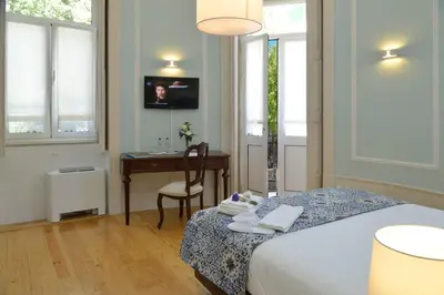 a bedroom with a bed and a desk and a table at Dukes Corner Guest House in Porto