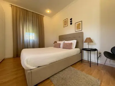 a bedroom with a large white bed with a window at Burgães II Apartment in Porto