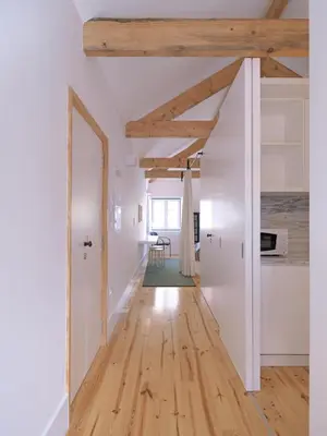 an open hallway with white walls and wooden beams at FLH Porto Modern Rooftop in Porto
