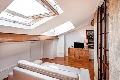 an attic living room with a skylight at VIVA Almada Flats in Porto
