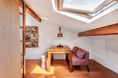a room with a table and a chair and a skylight at VIVA Almada Flats in Porto