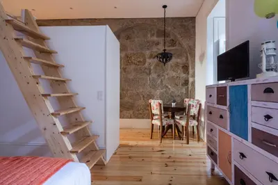 a bedroom with a bed and a table with a tv at VIVA Almada Flats in Porto