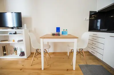 a small table in a kitchen with white chairs at LivingPorto Apartments by Porto City Hosts in Porto