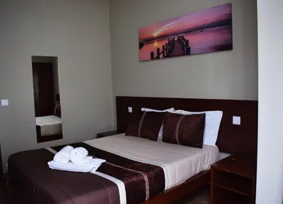 a hotel room with a bed with towels on it at GuestHouse Belo Horizonte in Porto