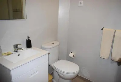 a white bathroom with a toilet and a sink at GuestHouse Belo Horizonte in Porto