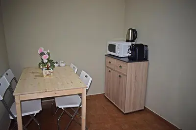 a dining room table with a microwave on top of it at GuestHouse Belo Horizonte in Porto