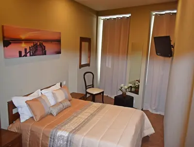 a bedroom with a bed and a television in it at GuestHouse Belo Horizonte in Porto