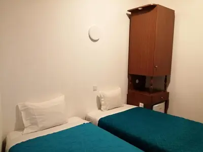 a small room with two beds and a cabinet at Residencia Vale Formoso in Porto
