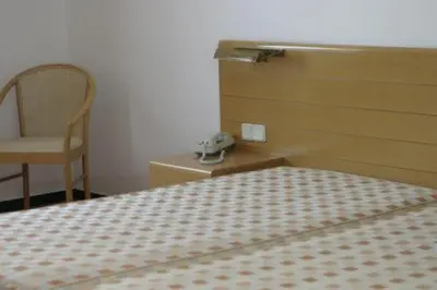 a bedroom with a bed and a chair and a phone at Hotel Douro in Porto