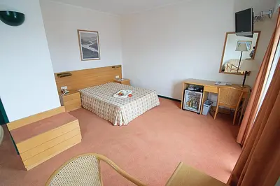 a room with a bed and a table and a desk at Hotel Douro in Porto