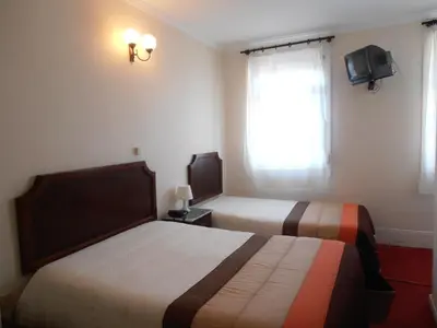 a hotel room with two beds and a window at Hotel S. Marino in Porto