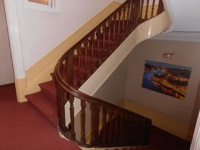 a staircase with a wooden railing and a painting on the wall at Hotel S. Marino in Porto