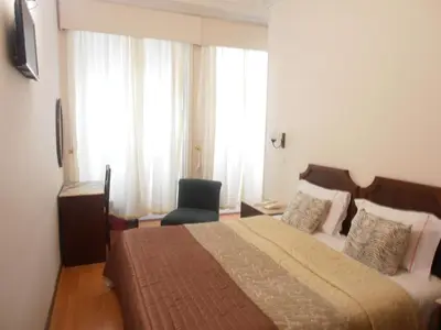 a bedroom with a bed and a chair in a room at Hotel S. Marino in Porto