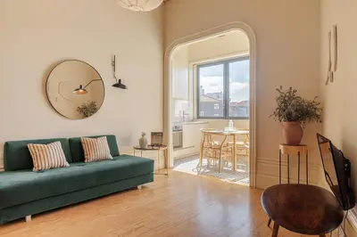 a living room with a green couch and a table at Oporto Maison Alves da Veiga in Porto