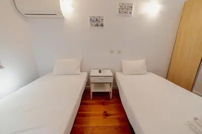 two beds in a small room with a small table at Dear Porto By Hosty in Porto