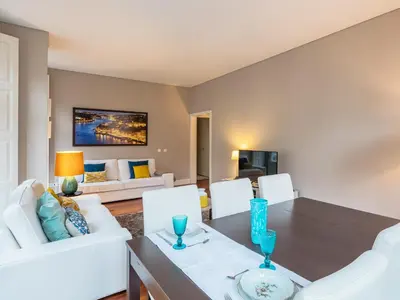 a dining room with a table and white chairs at Cardosas Boutique Apartment in Porto