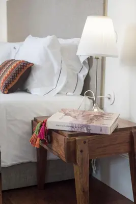 a bed with a table with a lamp and a book at bnapartments Carregal in Porto