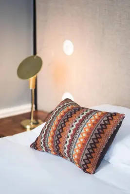 a pillow sitting on a bed next to a lamp at bnapartments Carregal in Porto