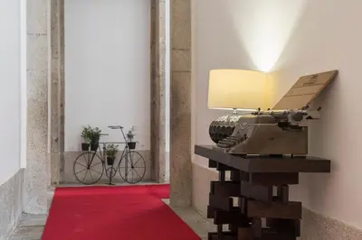 a table with a lamp on top of a red carpet at bnapartments Carregal in Porto
