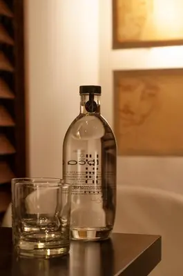 a bottle of water and a glass on a table at Porto Trindade Hotel in Porto