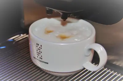 a coffee cup being prepared with a coffee machine at Porto Trindade Hotel in Porto