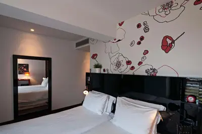 a bedroom with a bed with a black headboard and a mirror at Porto Trindade Hotel in Porto
