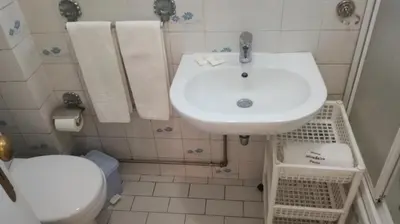a bathroom with a white sink and a toilet at Hotel Mira D'Aire in Porto