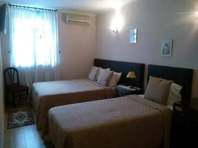 a hotel room with two beds and a window at Hotel Mira D'Aire in Porto