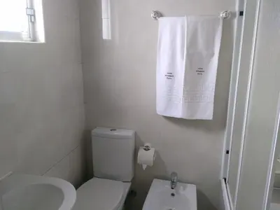 a bathroom with a toilet and a sink and towels at Hotel Mira D'Aire in Porto