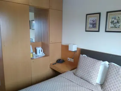 a bedroom with a bed and a cabinet with a mirror at Hotel Mira D'Aire in Porto
