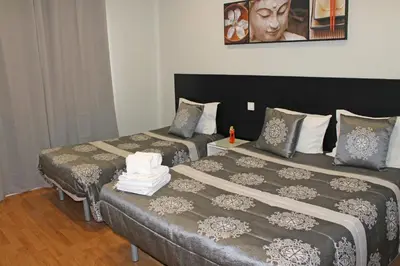 two beds in a hotel room with two bedsskirts at Lunar Guest House in Porto