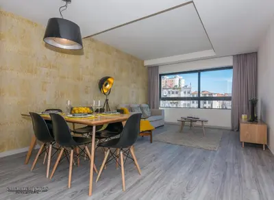 a living room with a dining room table and chairs at Passos Manuel by Innapartments in Porto