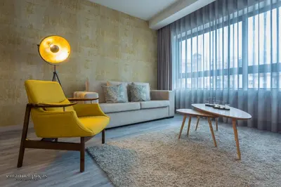 a living room with a yellow chair and a couch at Passos Manuel by Innapartments in Porto