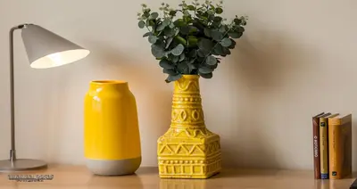 a yellow vase with a plant in it next to a lamp at Passos Manuel by Innapartments in Porto