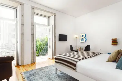 a white bedroom with a bed and a large window at Oporto Chic & Cozy - Bolhão in Porto