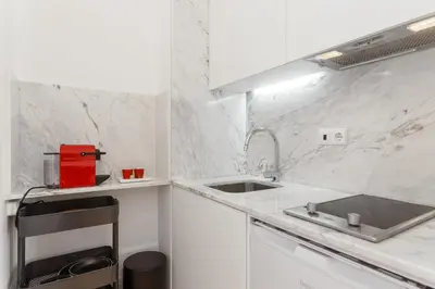 a kitchen with white marble walls and a sink at Oporto Chic & Cozy - Bolhão in Porto