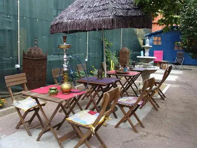 a group of tables with chairs and an umbrella at Porto Riad - Guest House in Porto