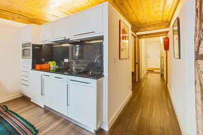 a kitchen with white cabinets and a wooden ceiling at Go2Oporto - Historical Center in Porto