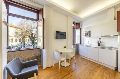 a kitchen and living room with a table and chairs at Try Oporto - São Lázaro in Porto