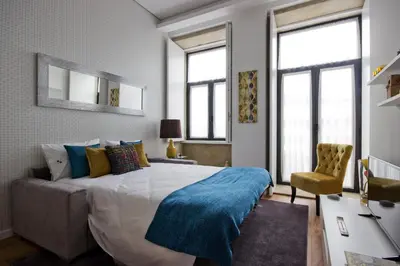 a bedroom with a large bed and a chair at OHH -Porto 4 you- Deluxe Apartment With Free Parking in Porto