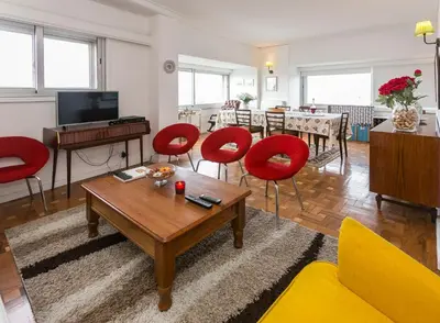 a living room with red chairs and a table at Apartamento Vintage 2 in Porto