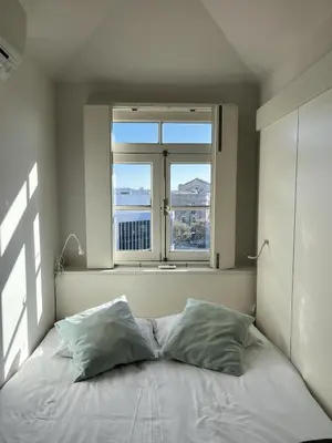 a bed with two pillows in a room with a window at Porto Cinema Apartments in Porto