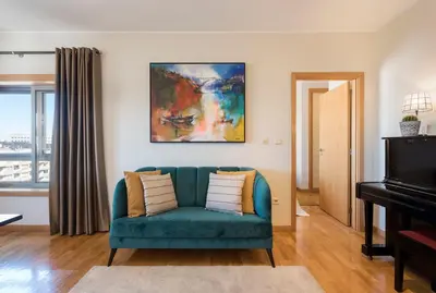 a living room with a blue couch and a piano at BBA Apartments Boavista - Casa da Música with free parking in Porto