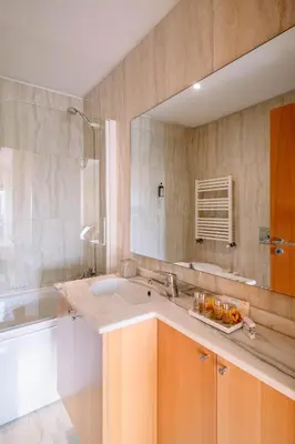 a bathroom with a sink and a large mirror at BBA Apartments Boavista - Casa da Música with free parking in Porto
