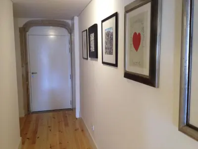 a hallway with a white door and pictures on the walls at SBV Perfect River View in Porto