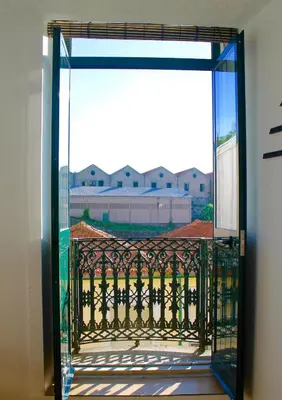 a balcony on the side of a building with a window at Douro Surf Hostel in Vila Nova de Gaia