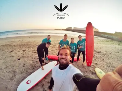 a group of people standing in the sand with surfboards at Douro Surf Hostel in Vila Nova de Gaia