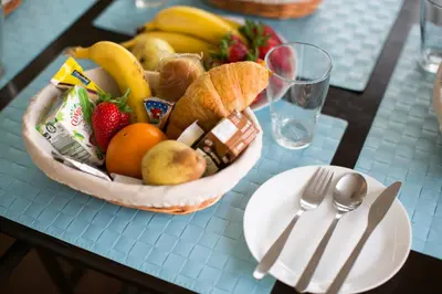 two plates of strawberries and bananas and a bowl of fruit at Douro Surf Hostel in Vila Nova de Gaia