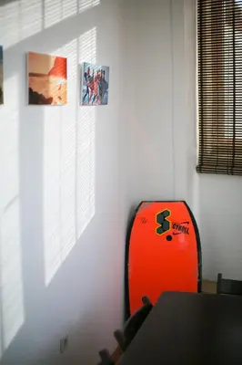 an orange suitcase sitting in a room with pictures on the wall at Douro Surf Hostel in Vila Nova de Gaia
